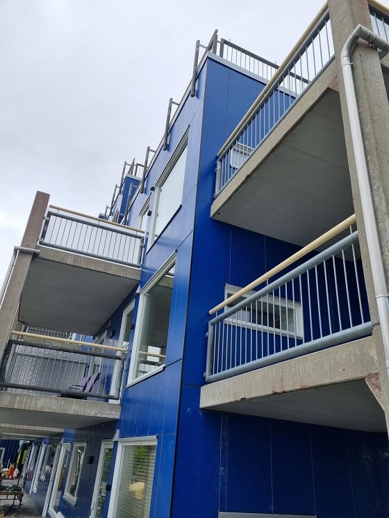 Blå bygning med flere verandaer.